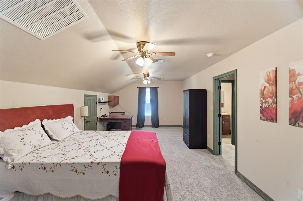 505 Highland Oak Point, TX 75068 - Photo 23 of 38 a spacious bedroom with a bed chandelier and a window