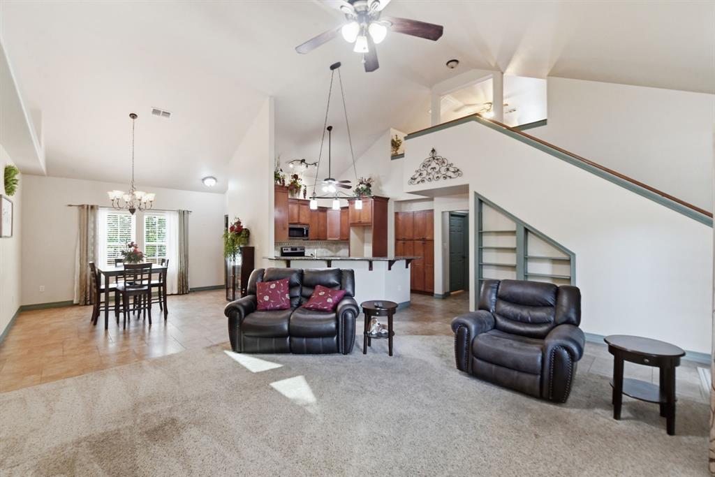 505 Highland Oak Point, TX 75068 - Photo 7 of 38 a living room with furniture and a chandelier