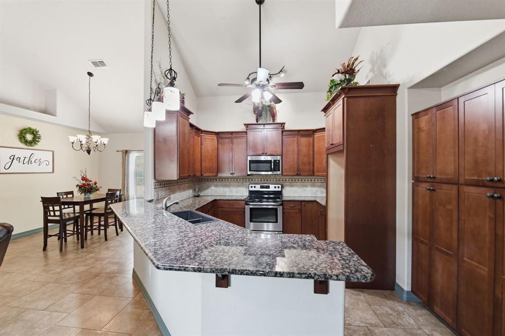 505 Highland Oak Point, TX 75068 - Photo 8 of 38 a kitchen with stainless steel appliances granite countertop a sink a stove and a refrigerator