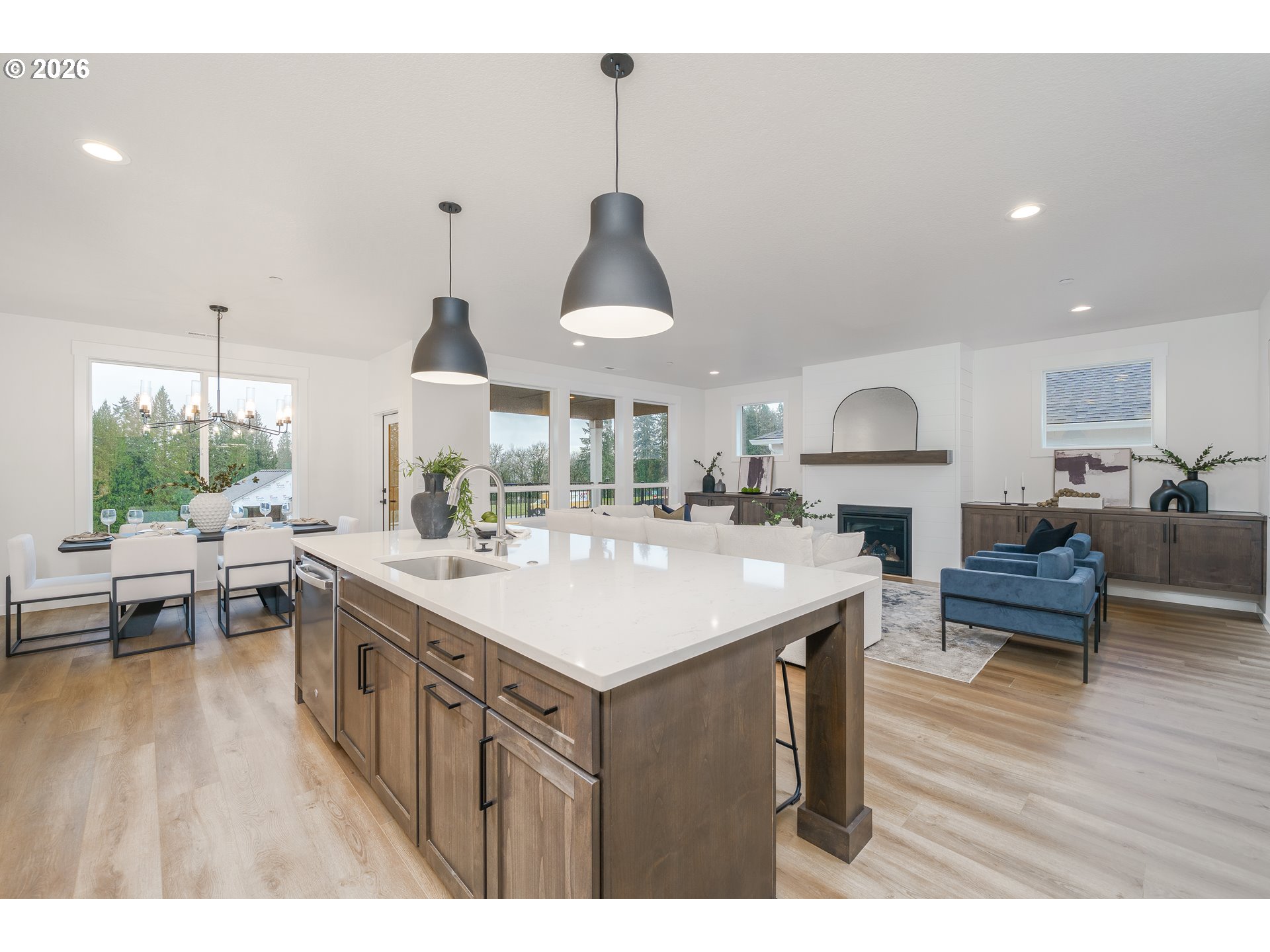 516 West 20th Way La Center, WA 98629 - Photo 24 of 45 a kitchen with kitchen island granite countertop a stove a sink a dining table and chairs with wooden floor