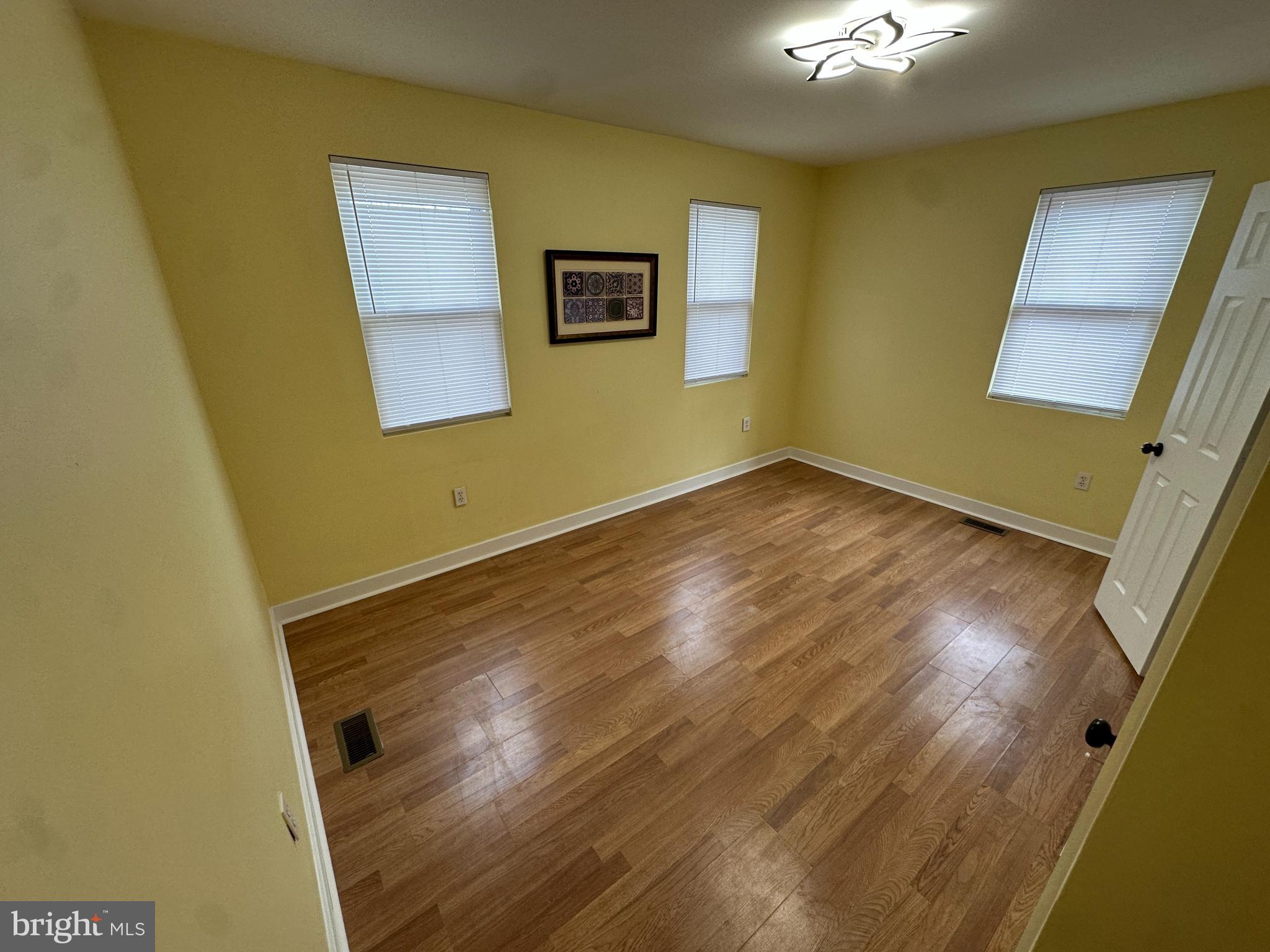 2712 Sherman Avenue Northwest Washington, DC 20001 - Photo 59 of 69 a view of an empty room with wooden floor and a window