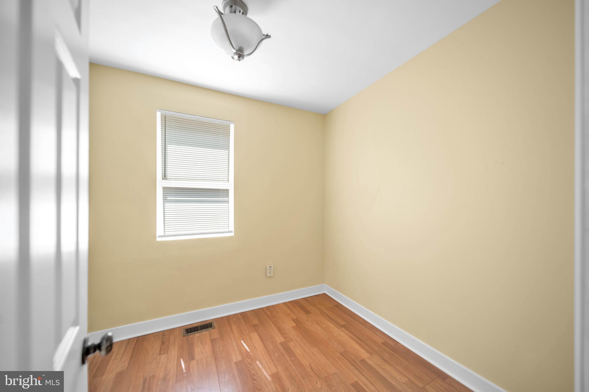 2712 Sherman Avenue Northwest Washington, DC 20001 - Photo 62 of 69 a view of an empty room with wooden floor and a window