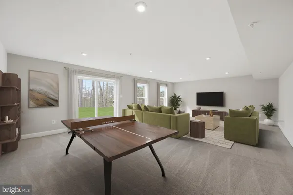 a living room with furniture a flat screen tv and a refrigerator