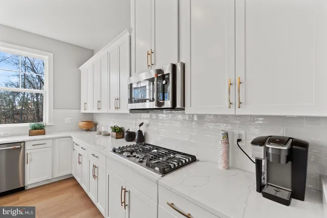 a kitchen with stainless steel appliances granite countertop a sink stove and cabinets