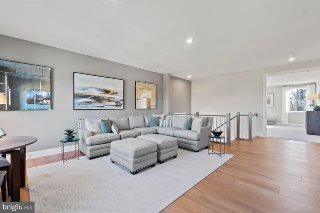 a living room with furniture and a view of kitchen