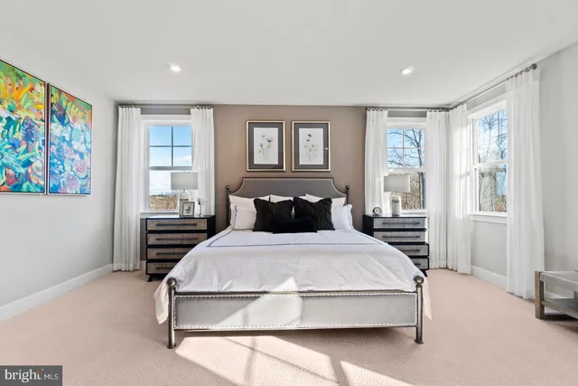 a spacious bedroom with a bed and glass window