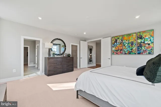 a bedroom with a large bed a rug and dresser