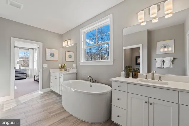 a bathroom with a sink double vanity granite tub and a mirror