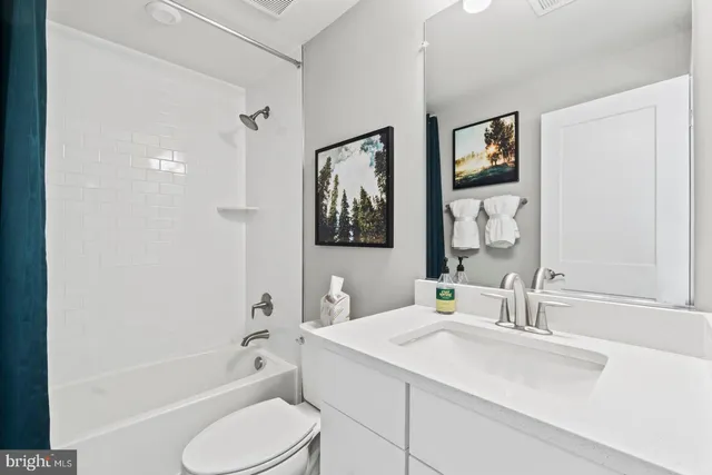 a bathroom with a granite countertop sink toilet tub and shower