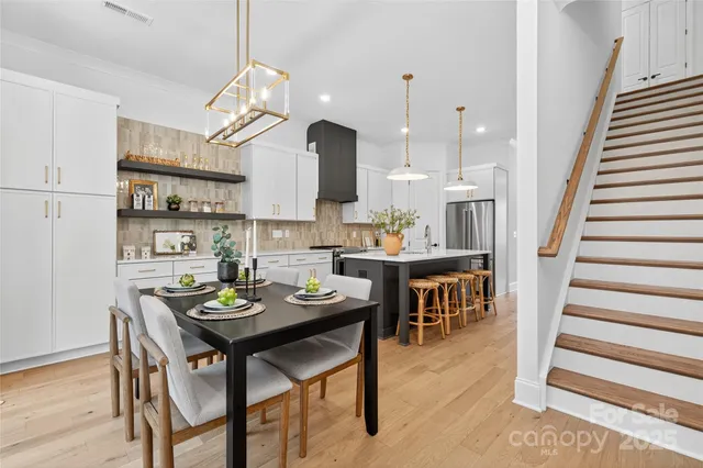 a kitchen with a dining table chairs and white cabinets