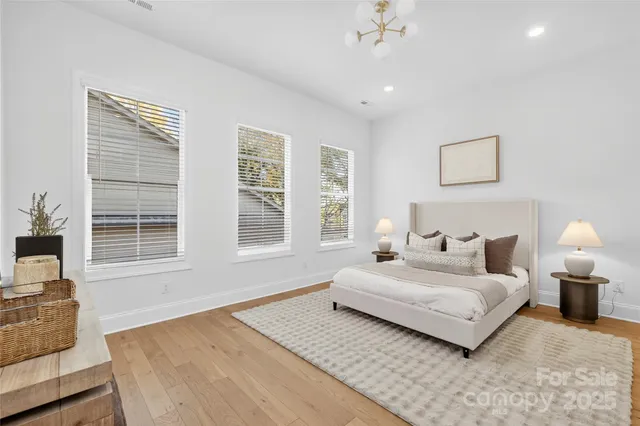 a spacious bedroom with a bed and a chandelier