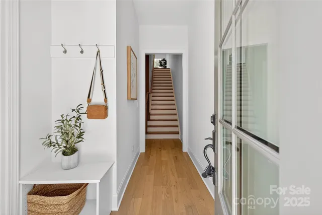 a view of a hallway with wooden floor and staircase