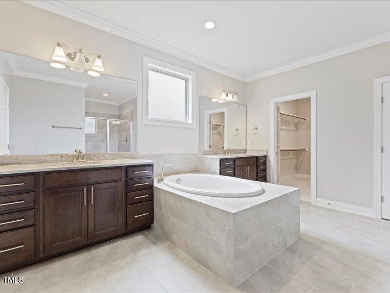1814 Capstone Drive Durham, NC 27713 - Photo 25 of 32 a spacious bathroom with a tub double sink and mirror