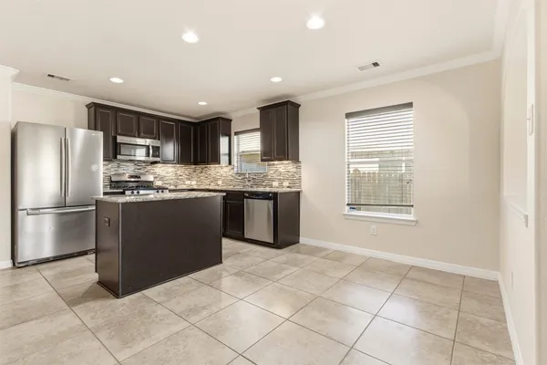 a kitchen with stainless steel appliances granite countertop a stove a sink a microwave and a refrigerator