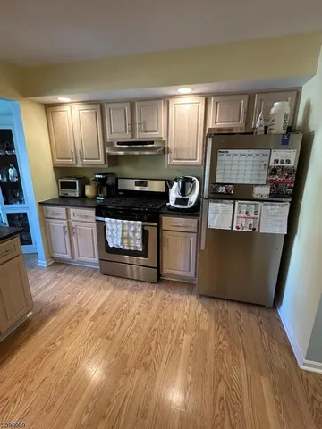 a kitchen with stainless steel appliances granite countertop a stove a sink and a refrigerator