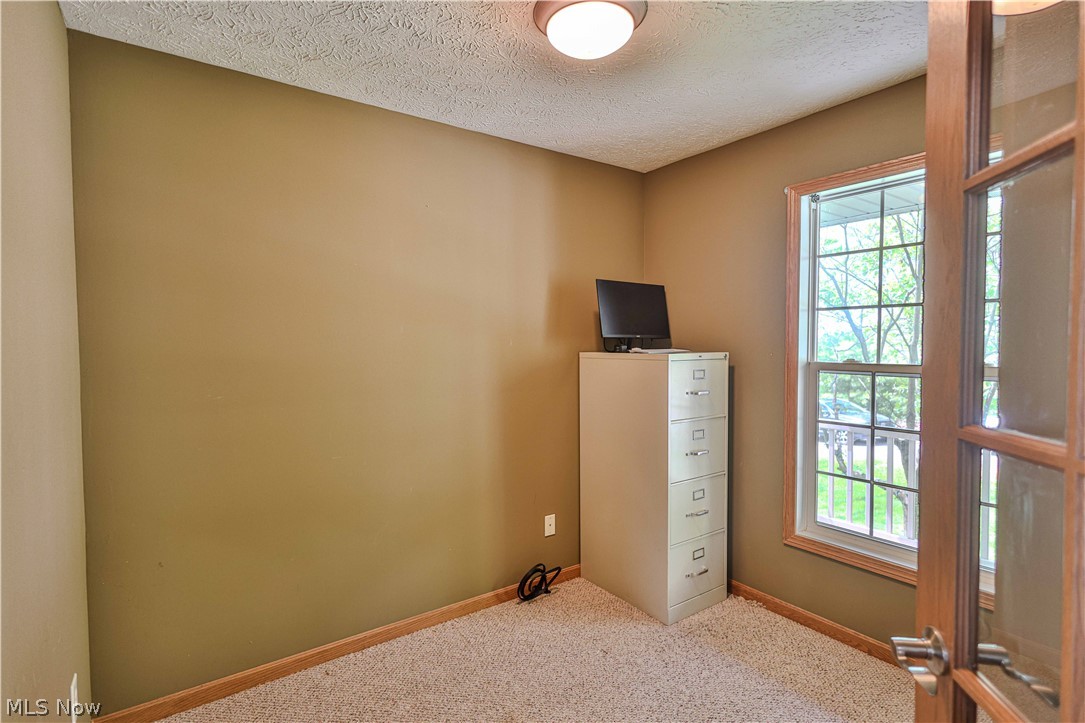 11154 Johnsford Road Southwest Beach City, OH 44608 - Photo 35 of 50 Compact room featuring textured ceiling, neutral wall paint, and light-colored carpet flooring