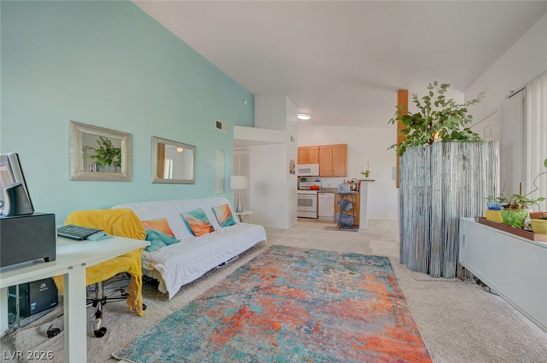 3318 North Decatur Boulevard, Unit 2072 Las Vegas, NV 89130 - Photo 8 of 50 A vibrant living area with a vaulted ceiling flows seamlessly into a well-appointed kitchen.