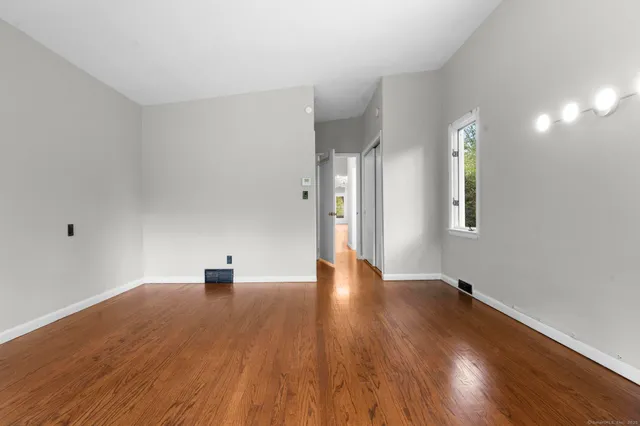 a view of empty room with wooden floor