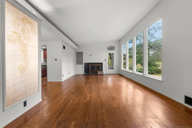 a view of empty room with wooden floor and fireplace