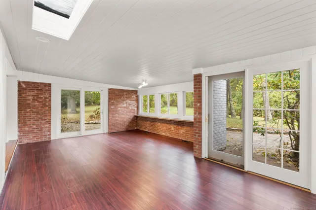 a view of a big room with wooden floor and windows