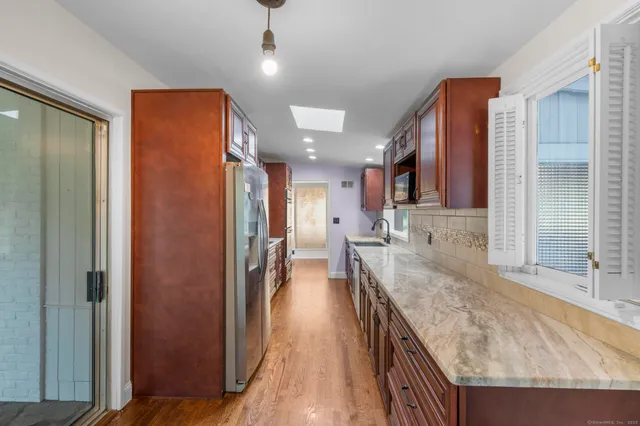a view of a kitchen with stainless steel appliances granite countertop a refrigerator and a sink