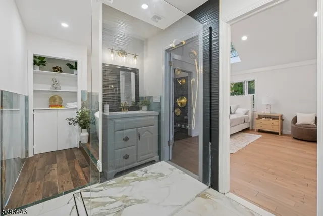 a en suite bathroom with a granite countertop sink and a mirror