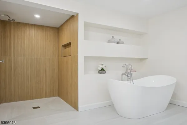 a white tub sitting next to a bathroom sink