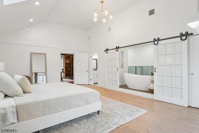 a bedroom with a large bed and a chandelier