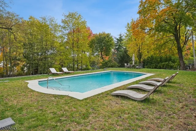 a view of a backyard with lawn chairs and a fire pit