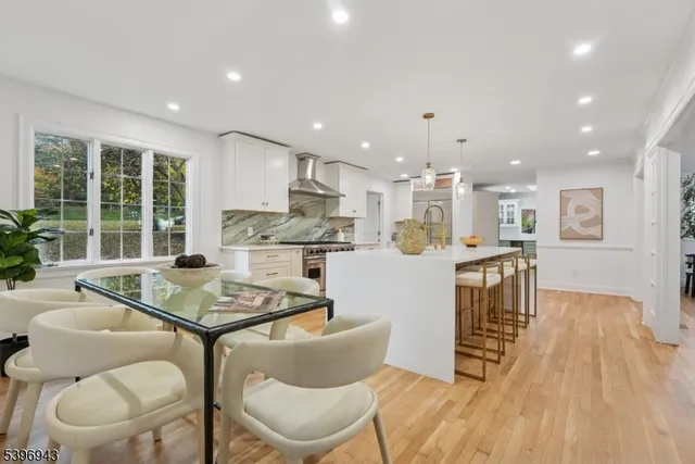 a living room with stainless steel appliances kitchen island granite countertop furniture and a wooden floor