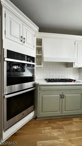 a kitchen with white cabinets and appliances