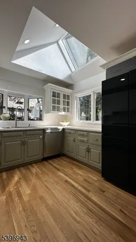 a kitchen with stainless steel appliances granite countertop a sink cabinets and wooden floor