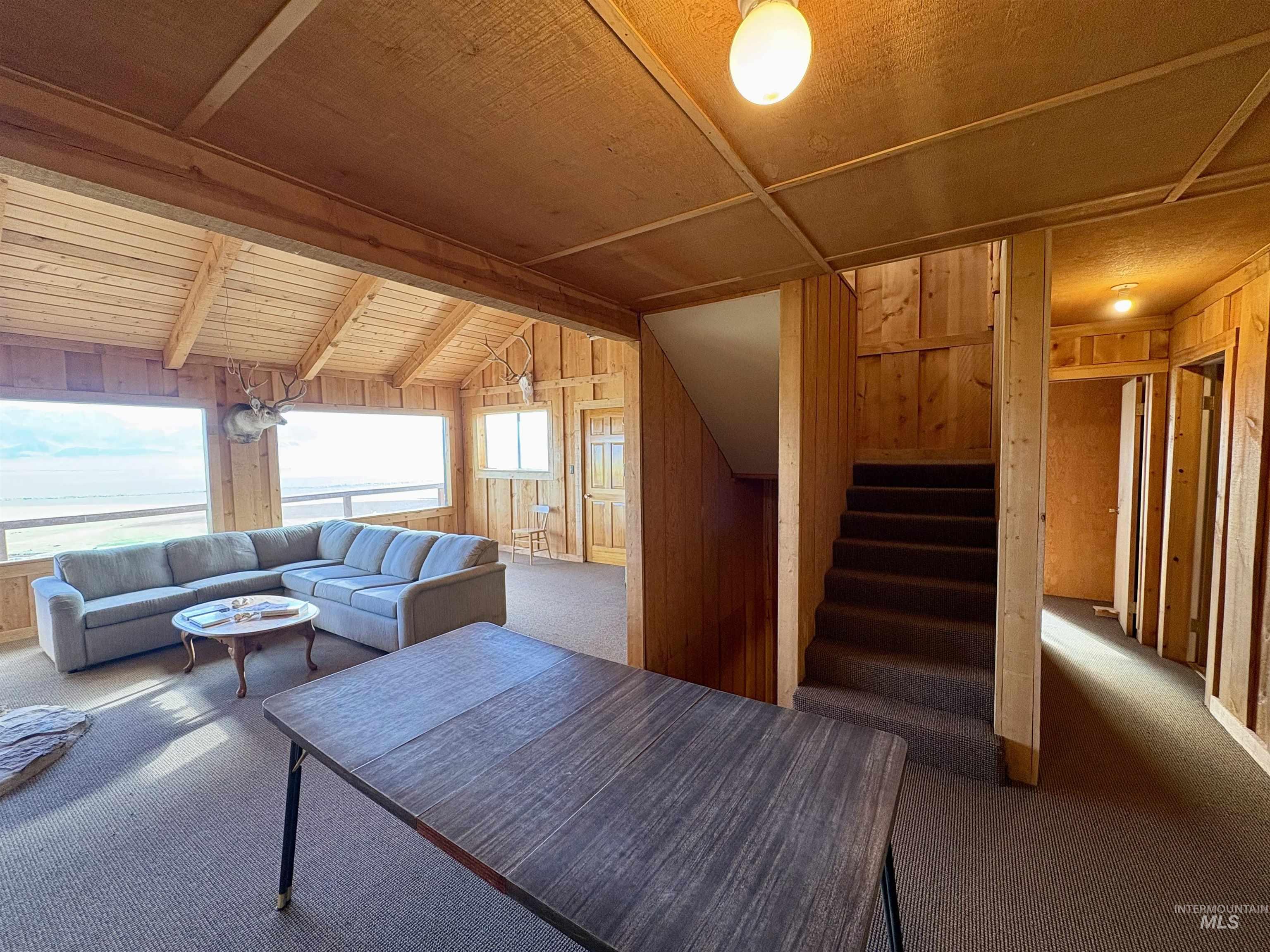 2040 Pahsimeroi River Road May, ID 83253 - Photo 19 of 29 Spacious interior featuring extensive wood paneling and exposed wood ceiling beams