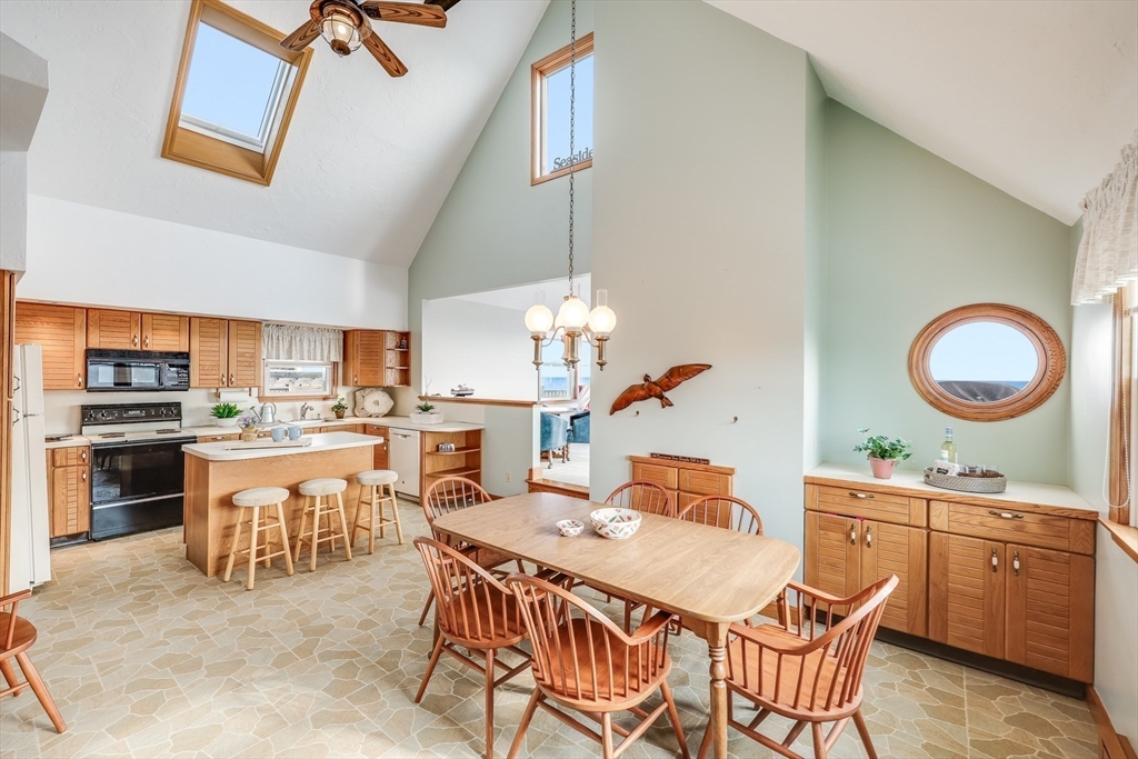 275 Phillips Road Sandwich, MA 02563 - Photo 25 of 40 a dining hall with stainless steel appliances kitchen island granite countertop a stove a sink a dining table and chairs with wooden floor