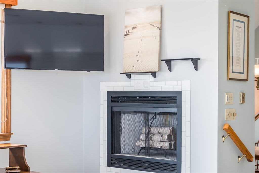 275 Phillips Road Sandwich, MA 02563 - Photo 32 of 40 a living room with a fireplace and a flat screen tv