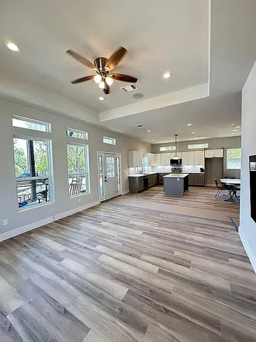 a view of an empty room with window and wooden floor