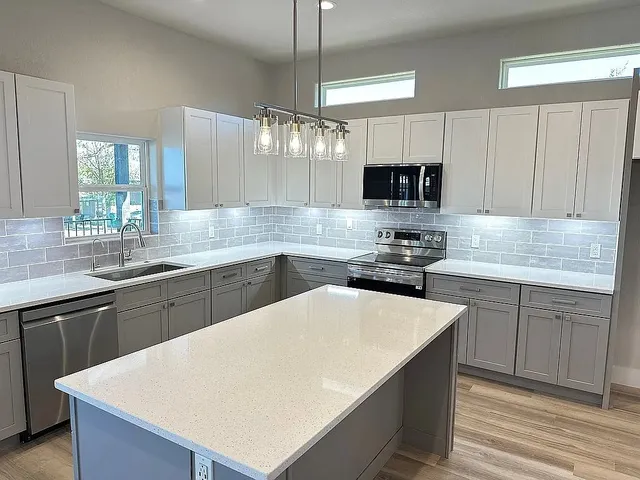 a kitchen with a sink a stove a microwave and cabinets