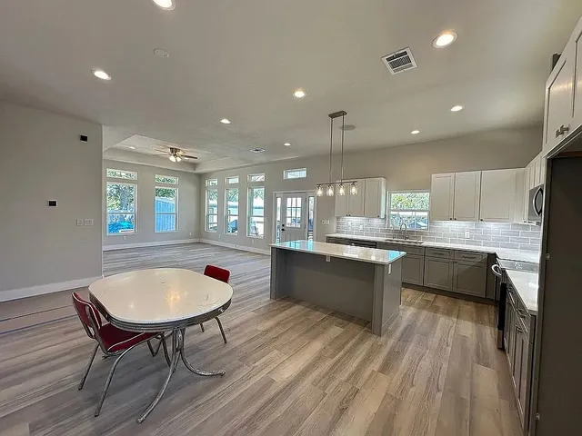 a kitchen with a table chairs sink and cabinets