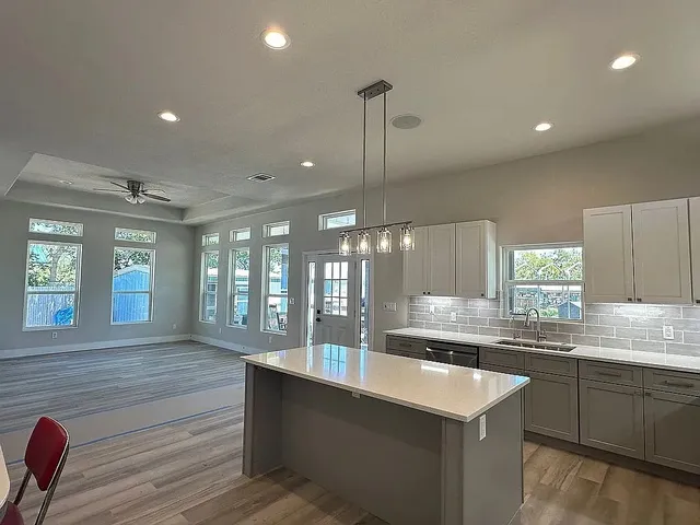 a kitchen with stainless steel appliances granite countertop a sink a stove and a refrigerator