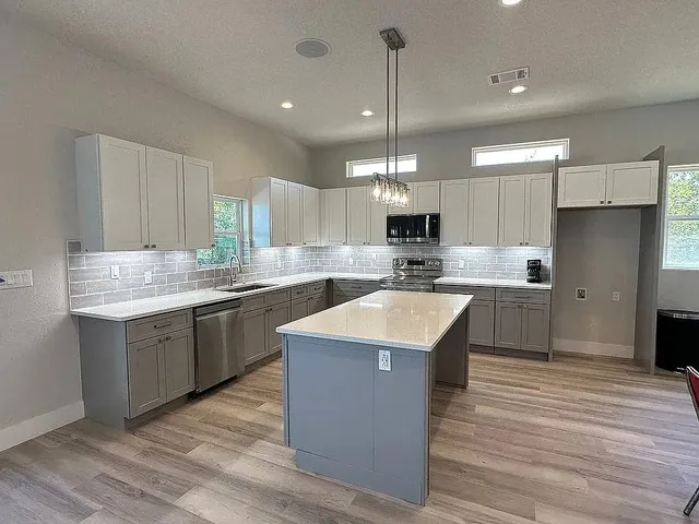 a kitchen with a sink a stove and cabinets