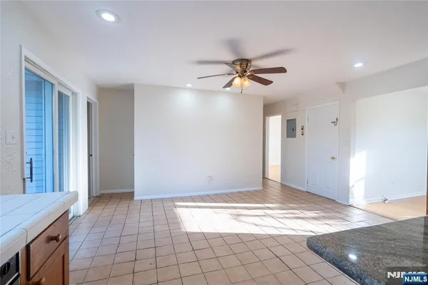 a view of a livingroom with a chandelier fan and windows