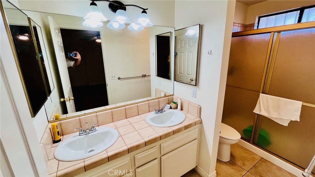 11911 Kiowa Road Apple Valley, CA 92308 - Photo 23 of 40 a bathroom with a sink a toilet and mirror