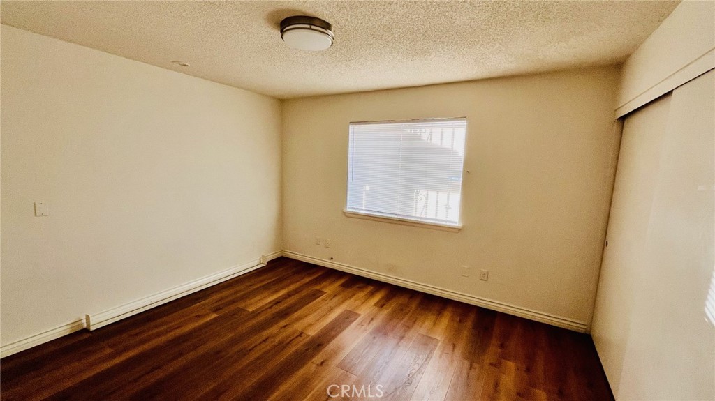 11911 Kiowa Road Apple Valley, CA 92308 - Photo 24 of 40 an empty room with wooden floor and windows