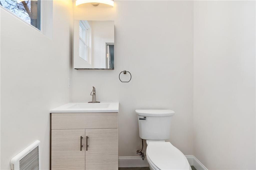 311 Elsdon Street Pittsburgh, PA 15214 - Photo 15 of 35 a bathroom with a toilet sink vanity and mirror