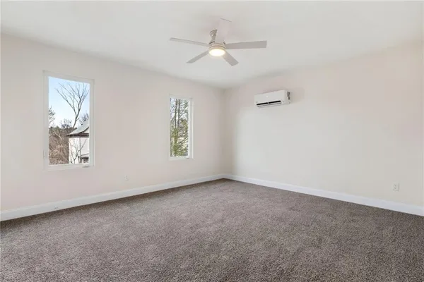 an empty room with windows and ceiling fan