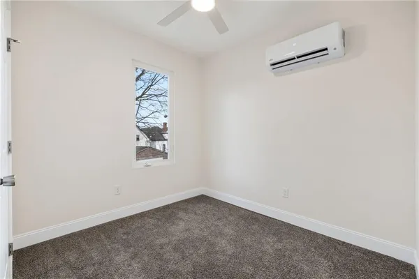 an empty room with a window and a ceiling fan
