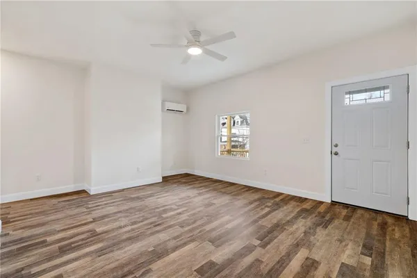 an empty room with wooden floor and windows