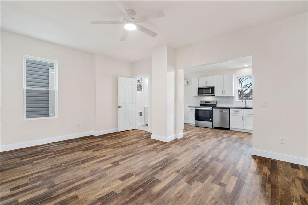 311 Elsdon Street Pittsburgh, PA 15214 - Photo 3 of 35 an empty room with wooden floor kitchen view and a window