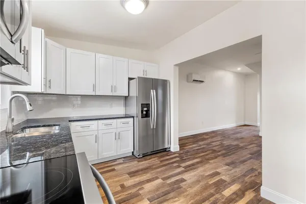 a kitchen with stainless steel appliances granite countertop a refrigerator and a stove top oven