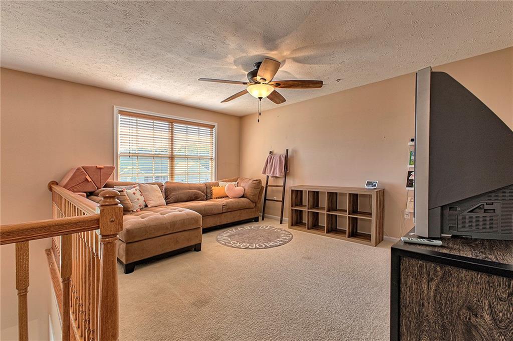 142 Lentz Road Latrobe, PA 15650 - Photo 17 of 32 a living room with furniture a flat screen tv and ceiling fan